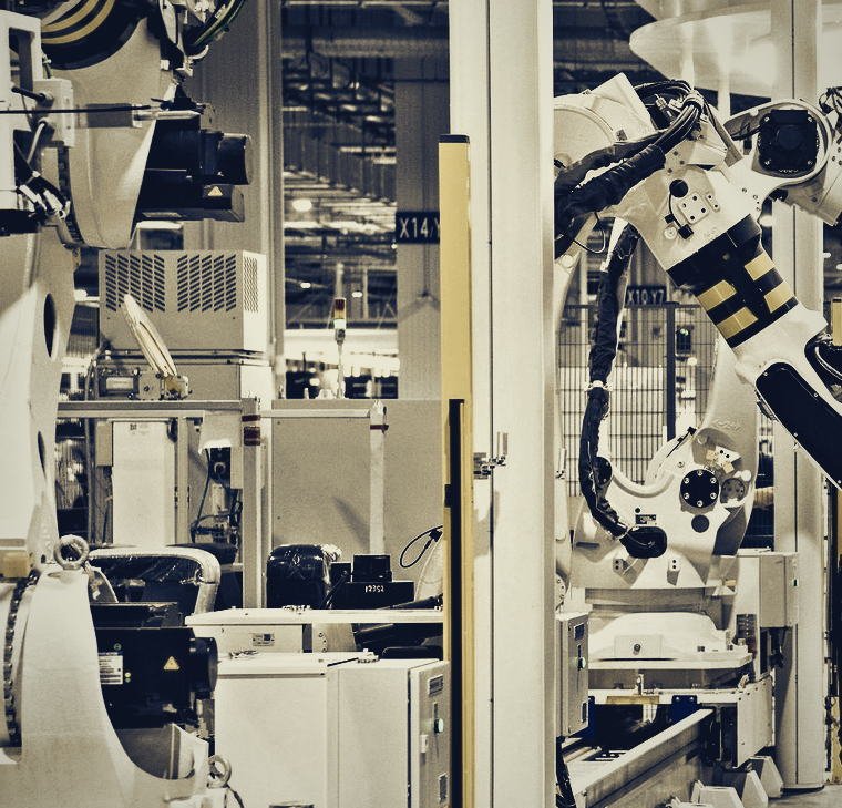Brazos robotizados de una l&iacute;nea de ensamble automotriz, con el poste amarillo de seguridad y el r&oacute;tulo de celda X14 al fondo